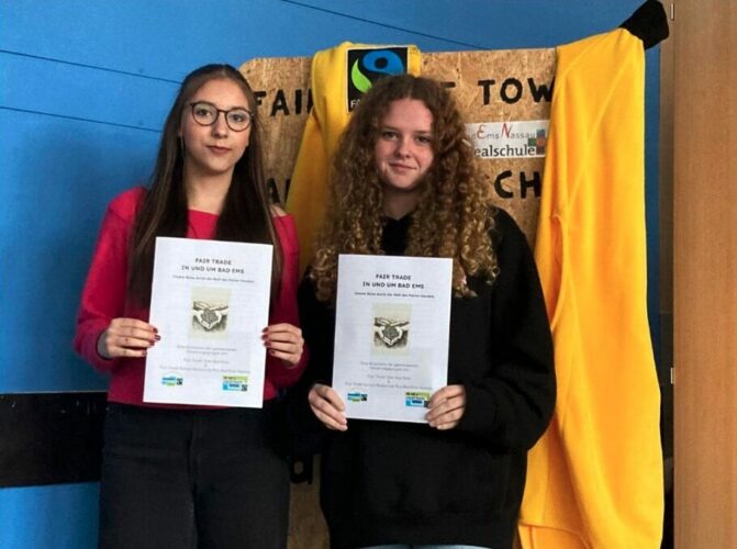 Zwei Schülerinnen halten eine Broschüre zum Thema Fair Trade in den Händen